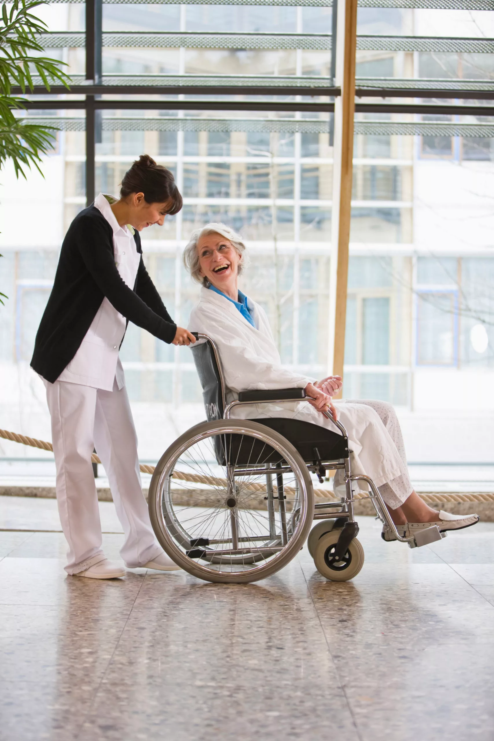 Image d'une vieille femme en fauteuil roulant et une infirmière.